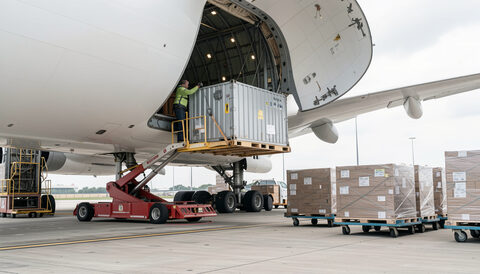 Obsługa cargo: kontener ULD wnoszony do luku bagażowego samolotu